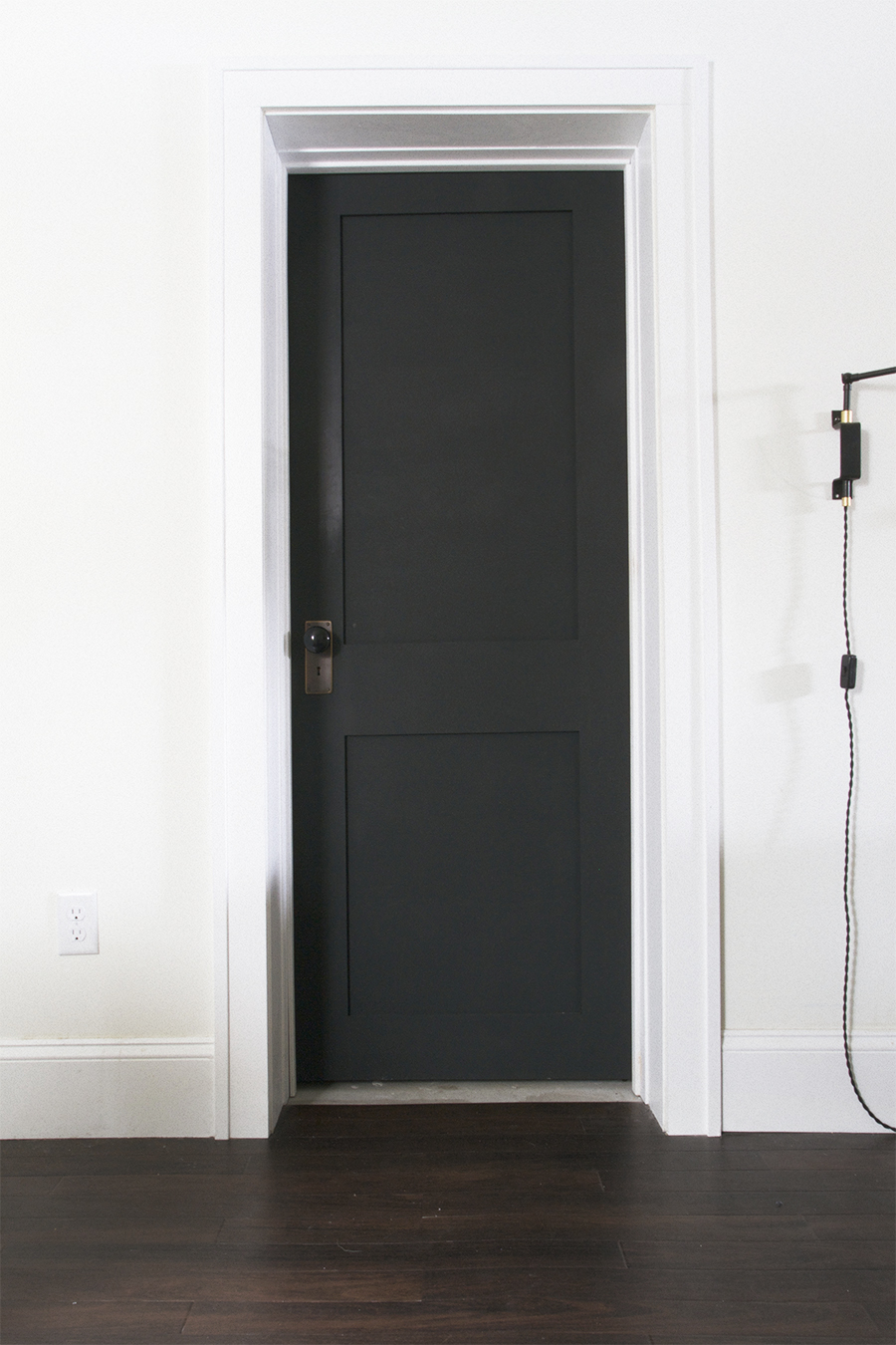 Black Door with Brass Hardware and Porcelain Knob