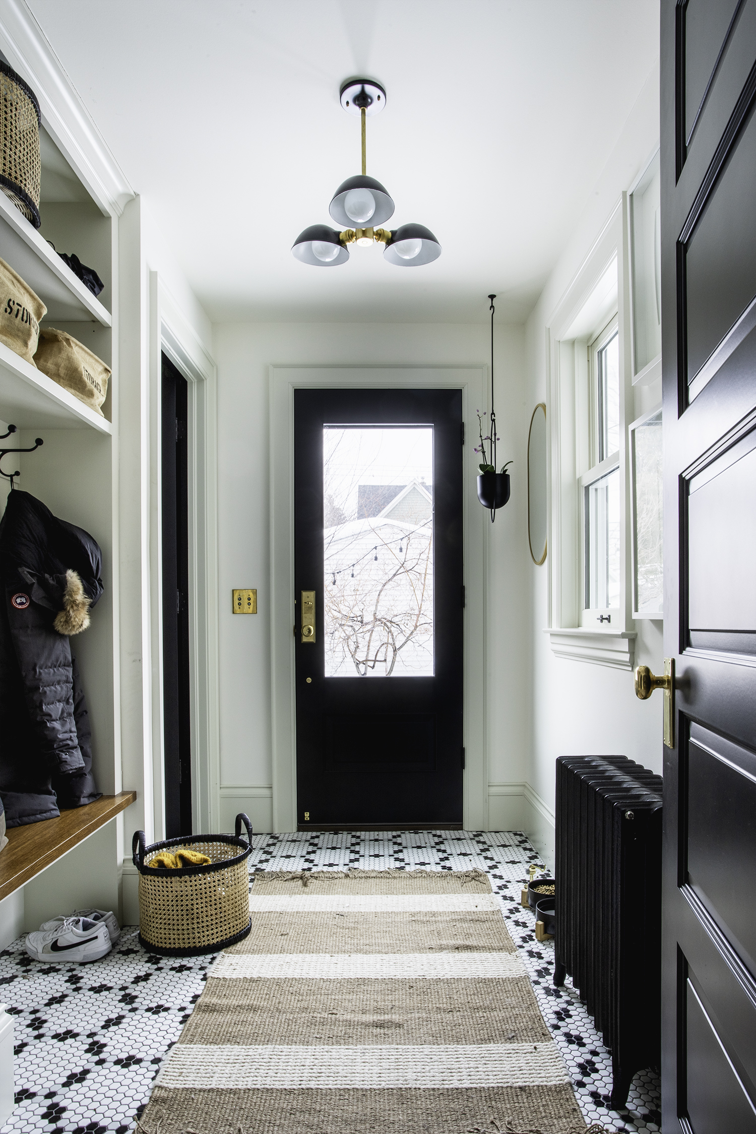 Mudroom with Black and white hex tile flooring and built in cabinetry